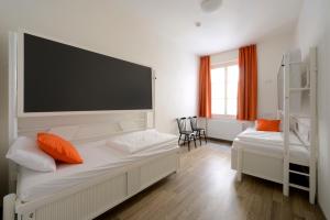 a room with two beds and a large screen at Safestay Prague Charles Bridge in Prague