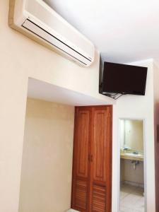 een kamer met een plafondventilator en een televisie bij Hotel Villa Campeche in Campeche