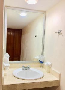 La salle de bains est pourvue d'un lavabo et d'un grand miroir. dans l'établissement Hotel Villa Campeche, à Campeche