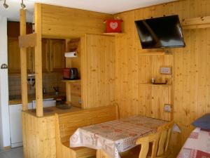 a room with a table and a tv in a cabin at Studio résidence Le Brelin aux MENUIRES in Les Menuires