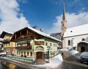 a building with a steeple and a church at Mesnerhaus Mühlbach in Mühlbach am Hochkönig