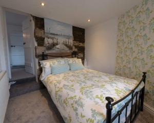 um quarto com uma cama grande num quarto em Platform 13 Railway Cottage em Conwy