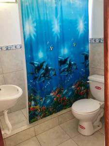 a bathroom with a fish tank shower curtain at Hotel Santorini in Cojimíes
