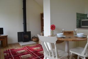 a dining room with a table and a fireplace at The Pigsty in Ashbourne