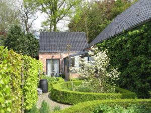 a garden in front of a house with hedges at B&B De Kastanjeboom in Jabbeke