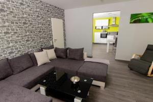 ein Wohnzimmer mit Sofa und Ziegelwand in der Unterkunft Ferienwohnung T. Müllers | Nr. 1 in Kövenig