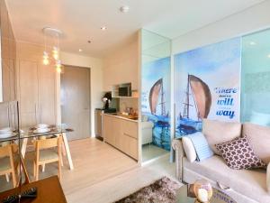 a living room with a couch and a kitchen at Veranda Residence Pattaya x Sea & Sky View in Na Jomtien