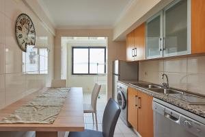 a kitchen with a table and a sink and a counter at BeGuest Cascais Inn Apartments in Cascais