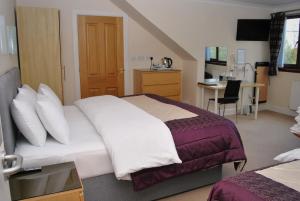a hotel room with a bed and a desk and a kitchen at The Old Schoolhouse Hotel in Larkhall