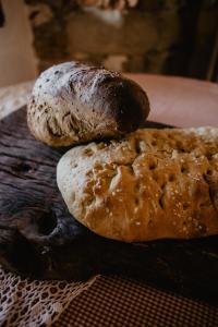 tre pagnotte di pane seduti su un tagliere di Agriturismo Le Piagge a Ponzone