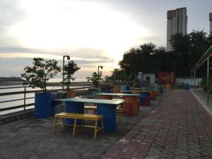 a row of tables and chairs next to the water at Mabohai Resort Klebang in Melaka