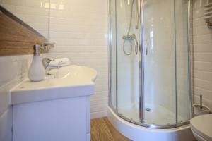a bathroom with a sink and a shower at Mistral Ustka in Ustka