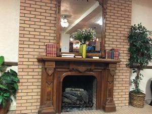 a fireplace with a mirror on top of it at Monte Villa Hotel in Monte Vista