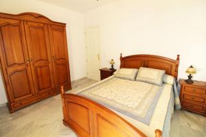 een slaapkamer met een houten bed en houten kasten bij Apartamento Calle Cruz in Fuengirola
