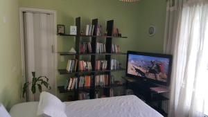 un dormitorio con una estantería llena de libros en Lo de Lala B&B con Energía Solar en Acassuso
