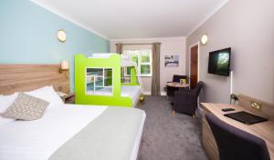 a hotel room with a bed and a desk with a chair at Treacys West County Conference and Leisure Centre in Ennis
