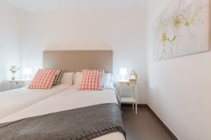 um quarto com uma cama grande e almofadas vermelhas e brancas em Apartamentos Cornellalux 2 em Cornellà de Llobregat