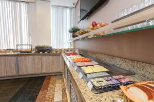 a kitchen with a counter filled with lots of food at Hotel Expressinho Aeroporto in Porto Alegre +14 photos