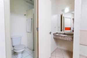 a bathroom with a toilet and a sink at Hotel Expressinho Aeroporto in Porto Alegre