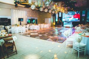 um salão de banquetes com cadeiras brancas e uma pista de dança em La Campiña Club Hotel & Spa em Santa Rosa
