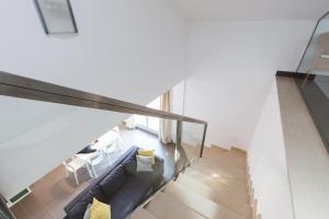 a living room with a couch and a staircase at Apartamentos Cornellalux 2 in Cornellà de Llobregat