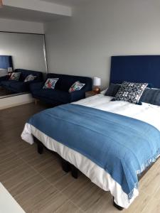 um quarto com uma cama grande e um sofá em Departamentos de Lujo ,costado Mall Plaza em Antofagasta