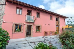 a house with a pink facade at El Campo de Petra in Grado