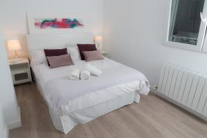 a bedroom with a white bed with two pillows at tuGuest Pedro Antonio Apartment in Granada