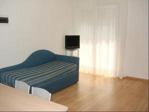 Aparthotel Royal في ليدو دي يسولو: غرفة معيشة مع أريكة زرقاء وتلفزيون