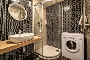 łazienka z umywalką i pralką w obiekcie Ruterra Apartment Cimburkova w Pradze +37 zdjęć