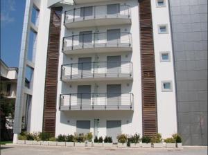 Aparthotel Royal في ليدو دي يسولو: مبنى طويل وبه شرفات على جانبه