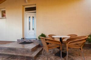 un patio con mesa y sillas junto a una pared en Guesthouse Villa Adria, en Malinska