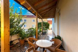 patio con mesa y sillas en el balcón en Guesthouse Villa Adria, en Malinska