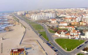 Leça Beach Flat ** Amazing Views ** Porto في ليكا دا بالميرا: اطلالة جوية على مدينة فيها شاطئ ومباني