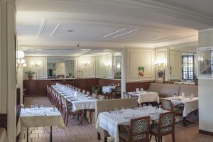 a dining room with tables and chairs with white tablecloths at Hôtel François 1er in Saint-Dizier