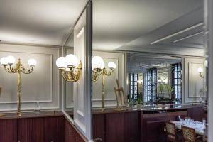 une salle à manger avec une table et un grand miroir dans l'établissement Hôtel François 1er, à Saint-Dizier