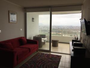 sala de estar con sofá rojo y ventana grande en Costa Mansa II, Avenida Costanera 3100 , Departamento 2201, en Coquimbo