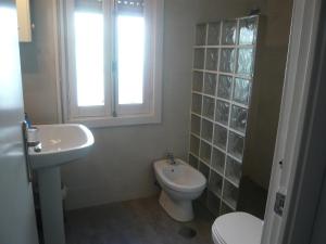 łazienka z umywalką, toaletą i oknem w obiekcie Chalet I con terraza en la playa w mieście San Pedro del Pinatar