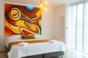 1 dormitorio con una gran pintura en la pared en Hotel Andinos Plaza Florencia, en Florencia
