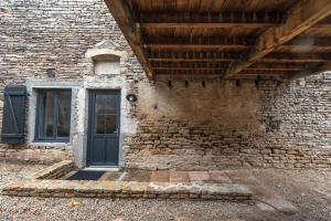 een bakstenen gebouw met een deur en een raam bij Gite de la Fée in Beaune