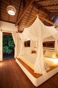 1 dormitorio con 1 cama con mosquitera en La Ferme De Georges en Atins