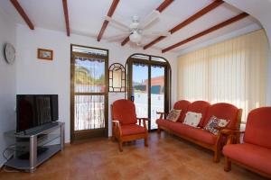 シウダー・ケサダにあるCH Villa Sola Ciudad Quesadaのリビングルーム(赤い椅子、薄型テレビ付)