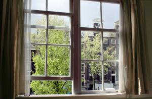 Una ventana abierta con vista a una ciudad en Hostel The Veteran, en Ámsterdam