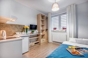 kuchnia i salon ze stołem i tacą z jedzeniem w obiekcie Apartamenty Novomiejska 17 w mieście Lublin