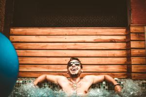a man laying in a bath tub with his mouth open at The Clock Hostel & Suites in Cartagena de Indias