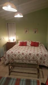 ein Schlafzimmer mit einem großen Bett mit zwei roten Kissen in der Unterkunft Lo de Lala B&B con Energía Solar in Acassuso