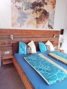 2 camas en una habitación con almohadas azules en Ferienhaus Hubertus für 8 Personen en Pill