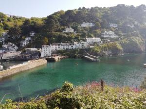 uma vista para um rio com casas numa colina em The House on the Props em Polperro