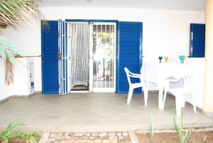 - une table et des chaises blanches sur la terrasse dans l'établissement Residence Amanda with pool, à Santa Maria