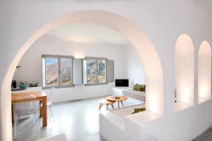 a living room with an archway and a table at Skyfall Suites - Adults Only in Pyrgos
